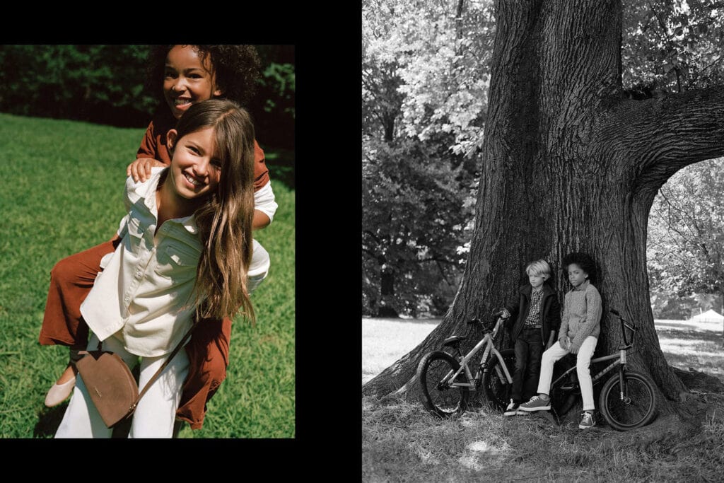 Children having fun outside near a large tree, with bikes and backpacks.