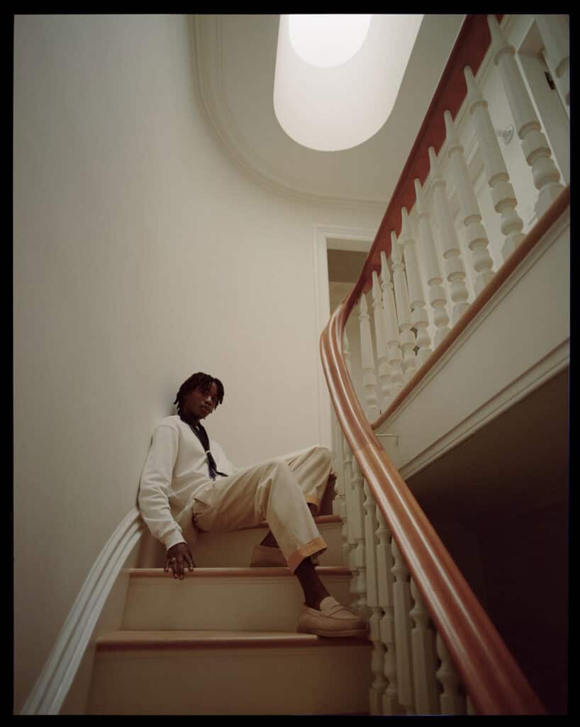 Man sitting on staircase railing in stylish interior, NYC 2021.