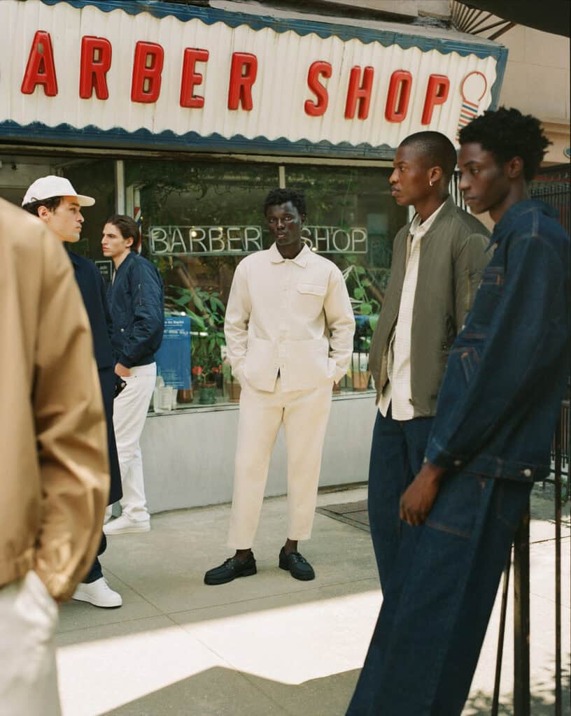 Men in stylish outfits outside Brooklyn barber shop, 2022.
