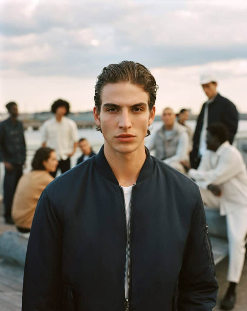 Stylish young man in ZARA MAN jacket on rooftop in Brooklyn, 2022.