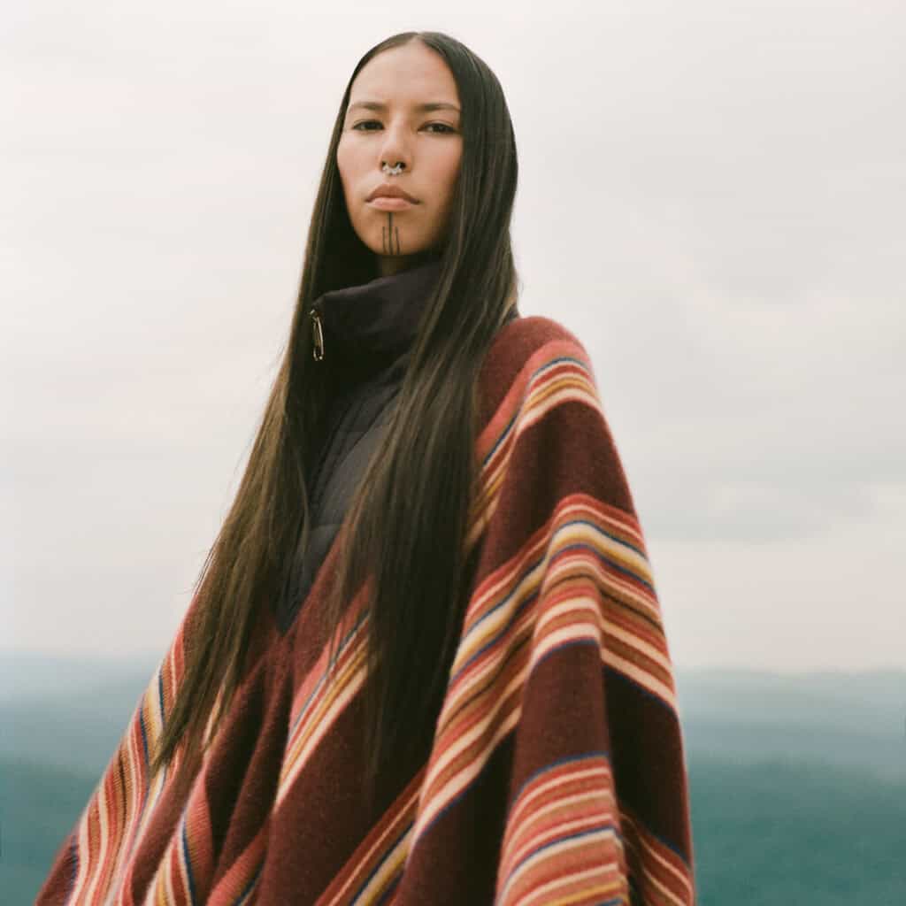 Portrait of Chloe showcasing modern femininity with long dark hair and layered clothing.