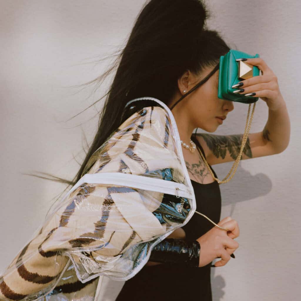 Stylish Bella Poarch holding a turquoise clutch and wearing trendy accessories.