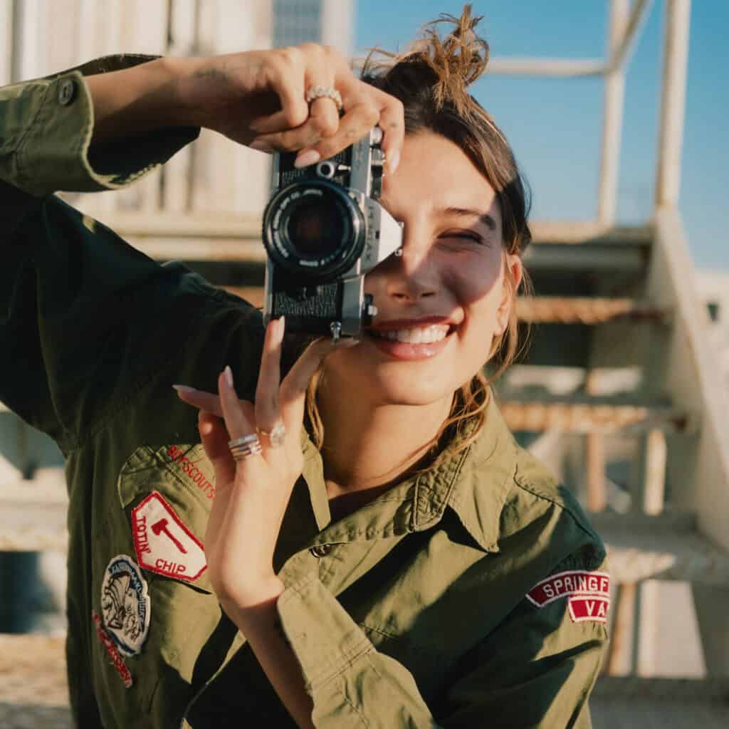 Hailey Bieber taking photos outdoors for Perfect Magazine shoot.