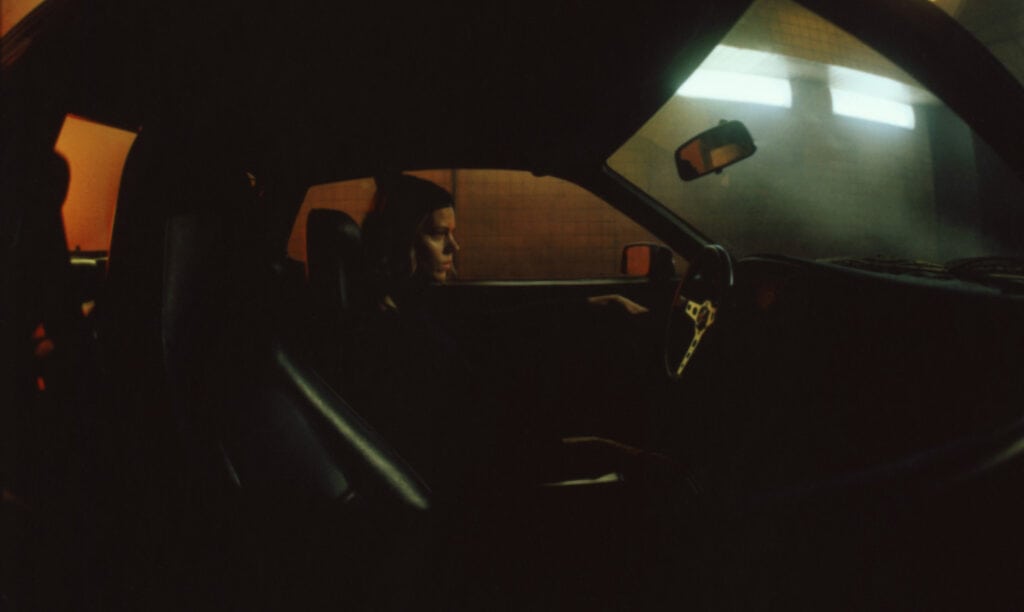 Interior view of a luxury car with a driver during sunset.