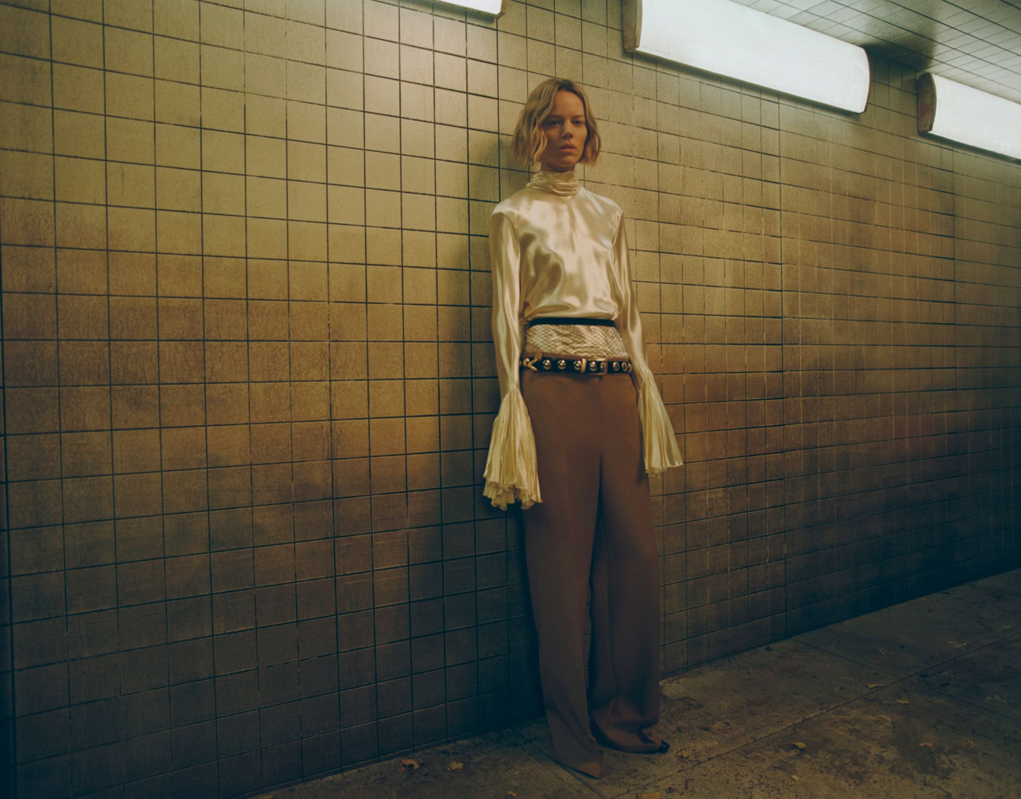 Elegant model wearing KHAITE Freja 2022 outfit in urban setting.