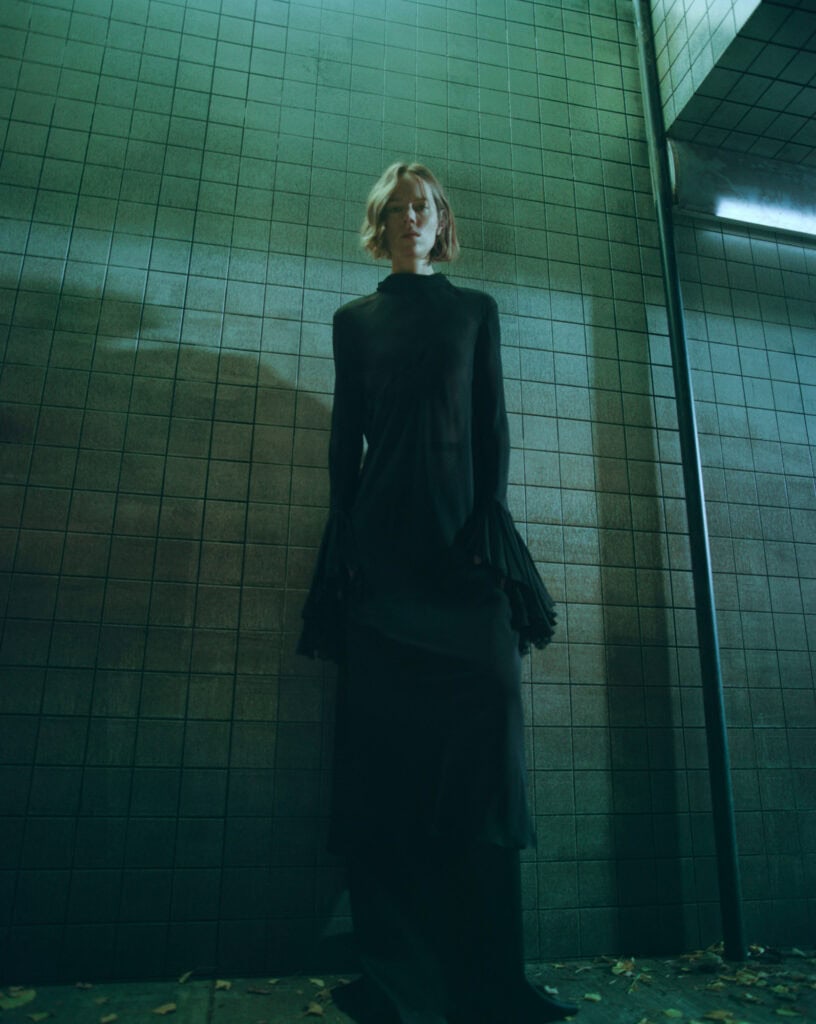 Model wearing KHAITE Freja dress in an urban setting, 2022.