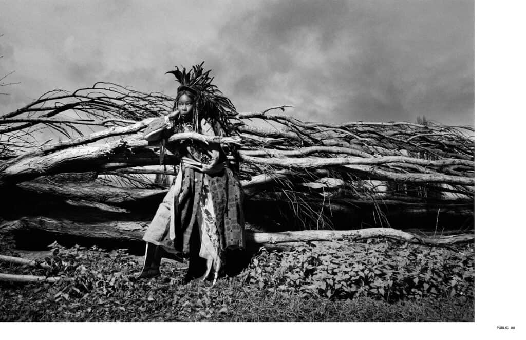 Woman standing in front of fallen trees, black and white photo.