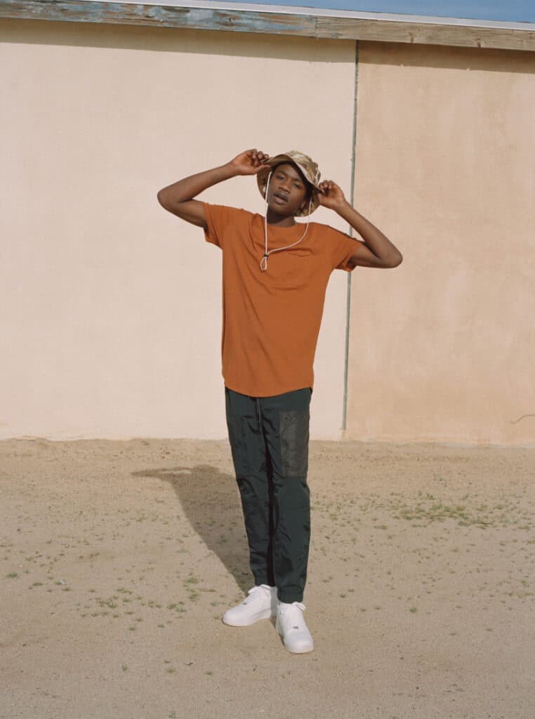 Young man wearing casual urban outfit in desert environment.