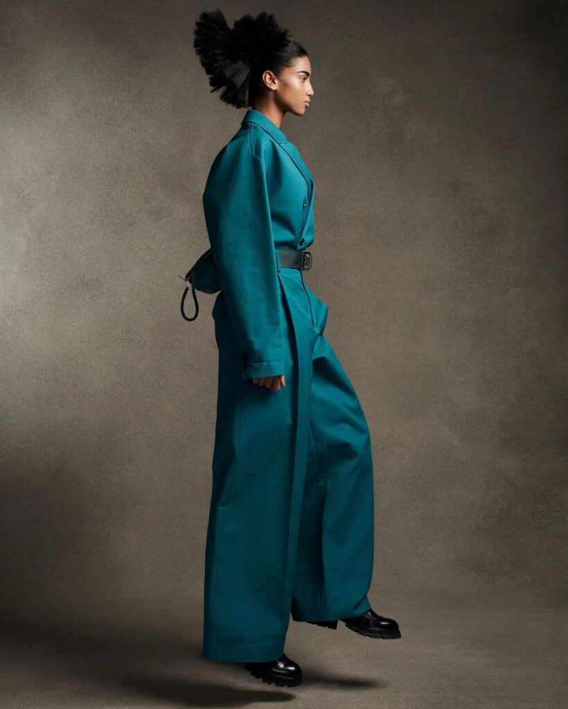 Fashion model in teal oversized coat and wide-leg pants for Vogue Proportions.