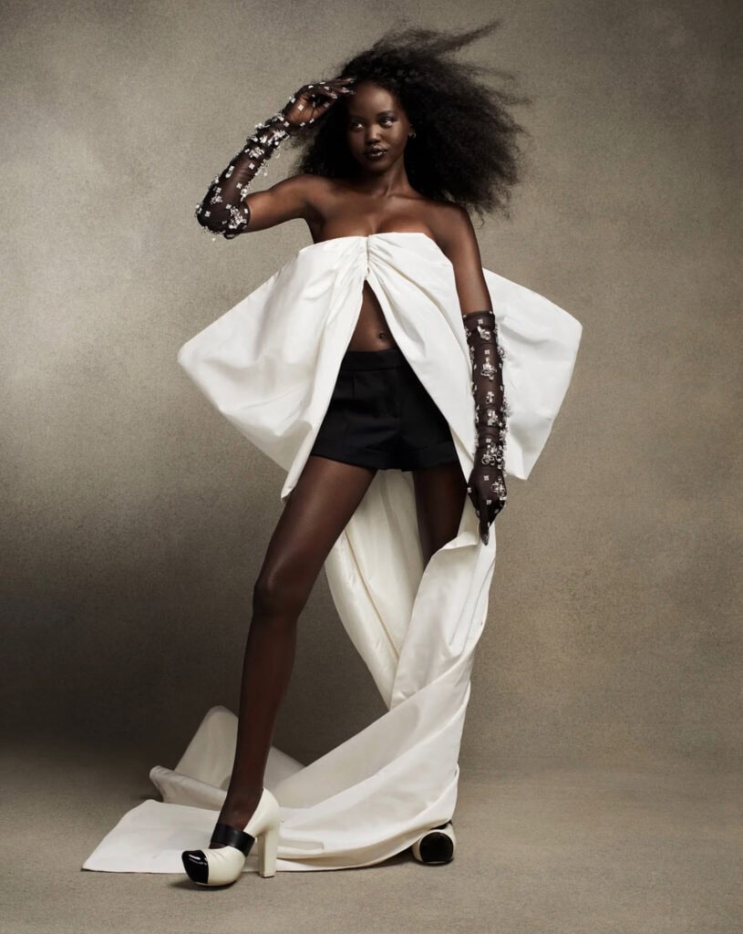 Model in avant-garde white and black fashion with dramatic accessories.
