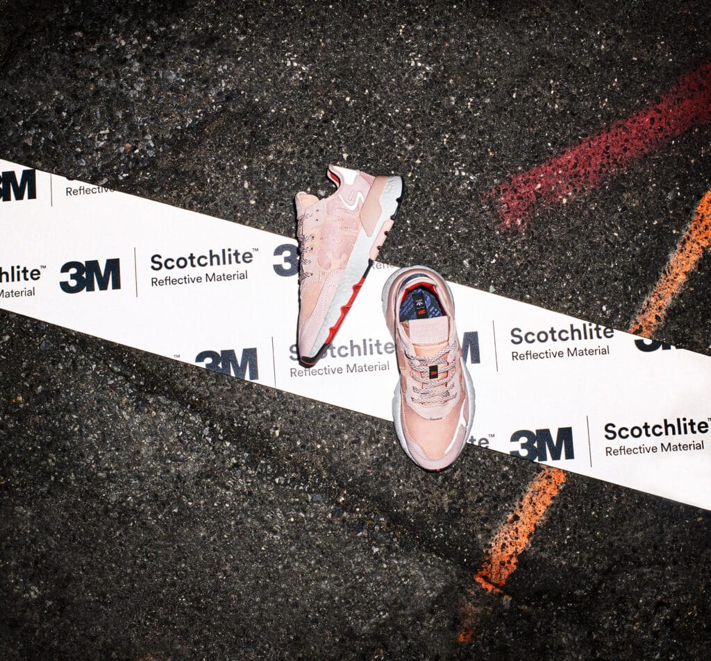 Adidas Nite Jogger sneakers displayed on a track with reflective tape for visibility.
