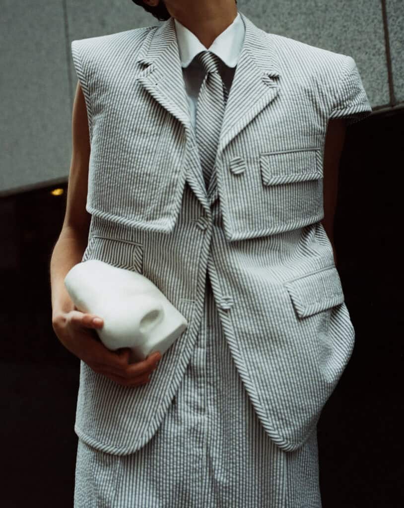 Elegant tailored suit with a white shirt and striped tie, showcasing modern menswear design.