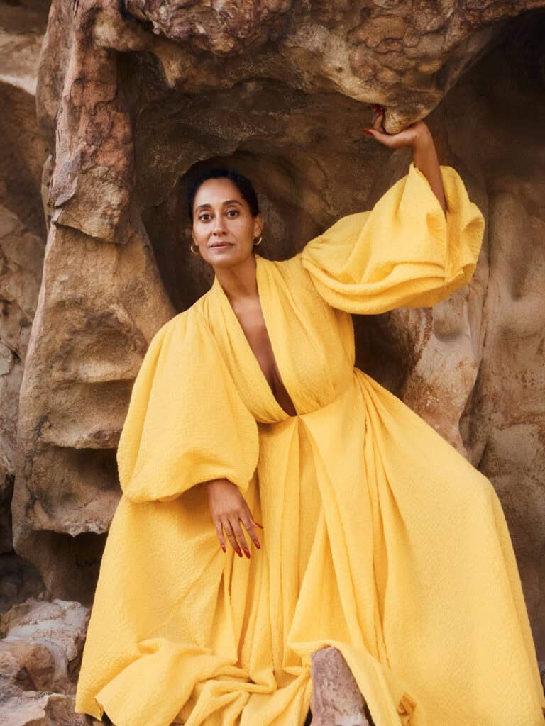 Tracee Ellis Ross in a yellow gown at a rocky outdoor location.