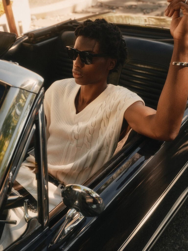 Stylish man in sunglasses driving vintage convertible car in Los Angeles.