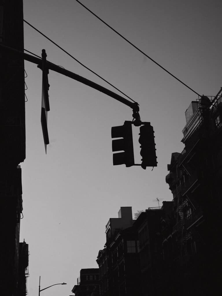 Urban street scene with traffic light and building silhouettes in NYC.