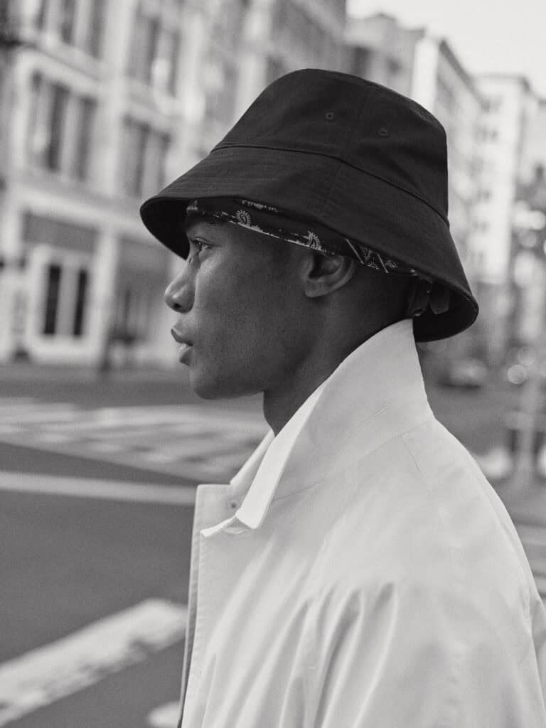 Stylish man wearing a bucket hat and white jacket in New York City.