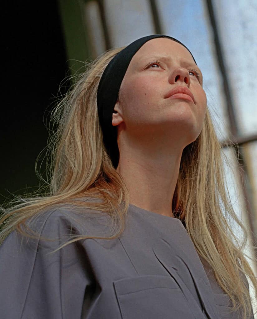 Mia Goth posing in a fashion shoot for Cultured Magazine, showcasing contemporary style and artistic.