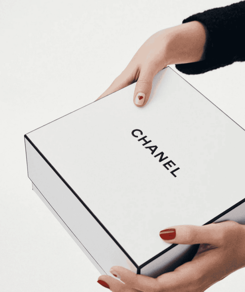Hand holding a Chanel gift box for Valentine's Day 2024.